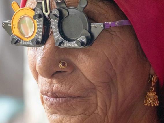 Starsza kobieta z założonymi okularami refrakcyjnymi.