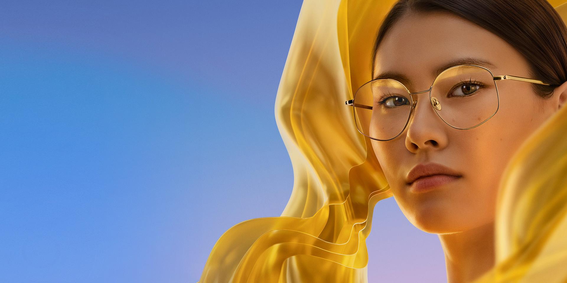Kobieta nosząca przezroczyste okulary z soczewkami ZEISS DuraVision Gold UV, nadającymi soczewkom subtelny, ale charakterystyczny złoty refleks.