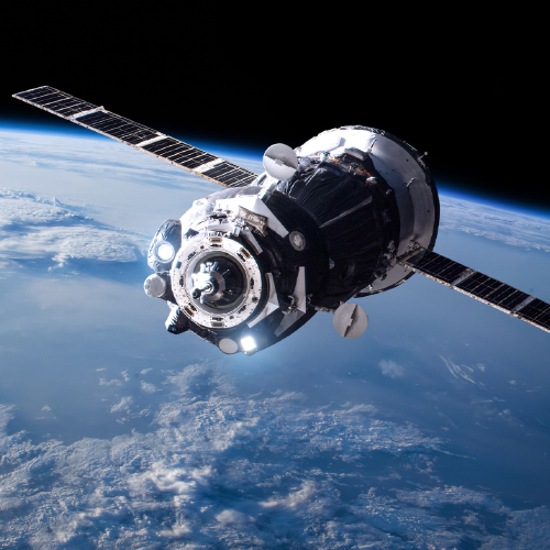 Zdjęcie satelity w przestrzeni kosmicznej, przelatującego nad Ziemią. 