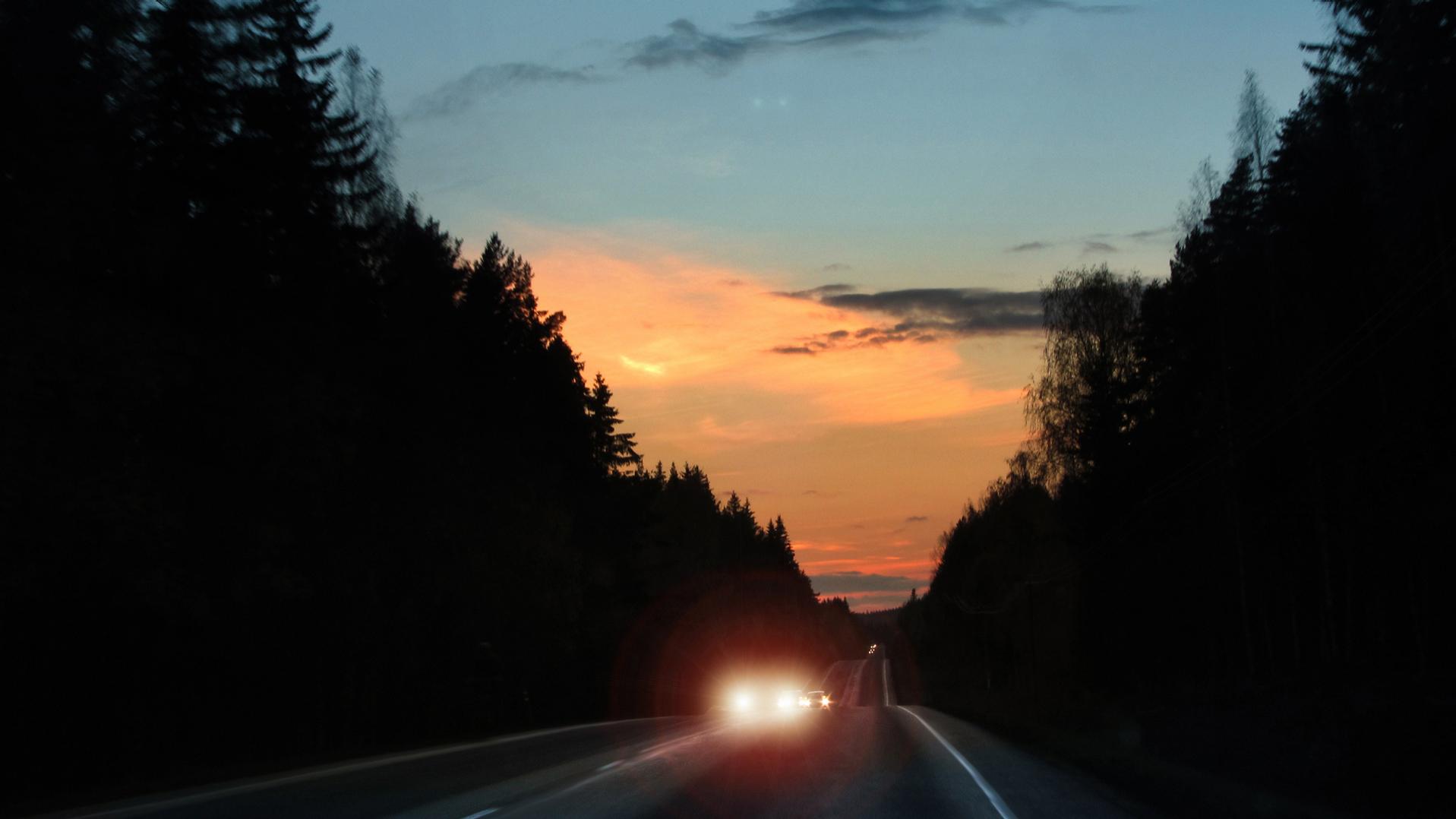 Reflektory samochodowe oślepiają w wieczornym ruchu ulicznym