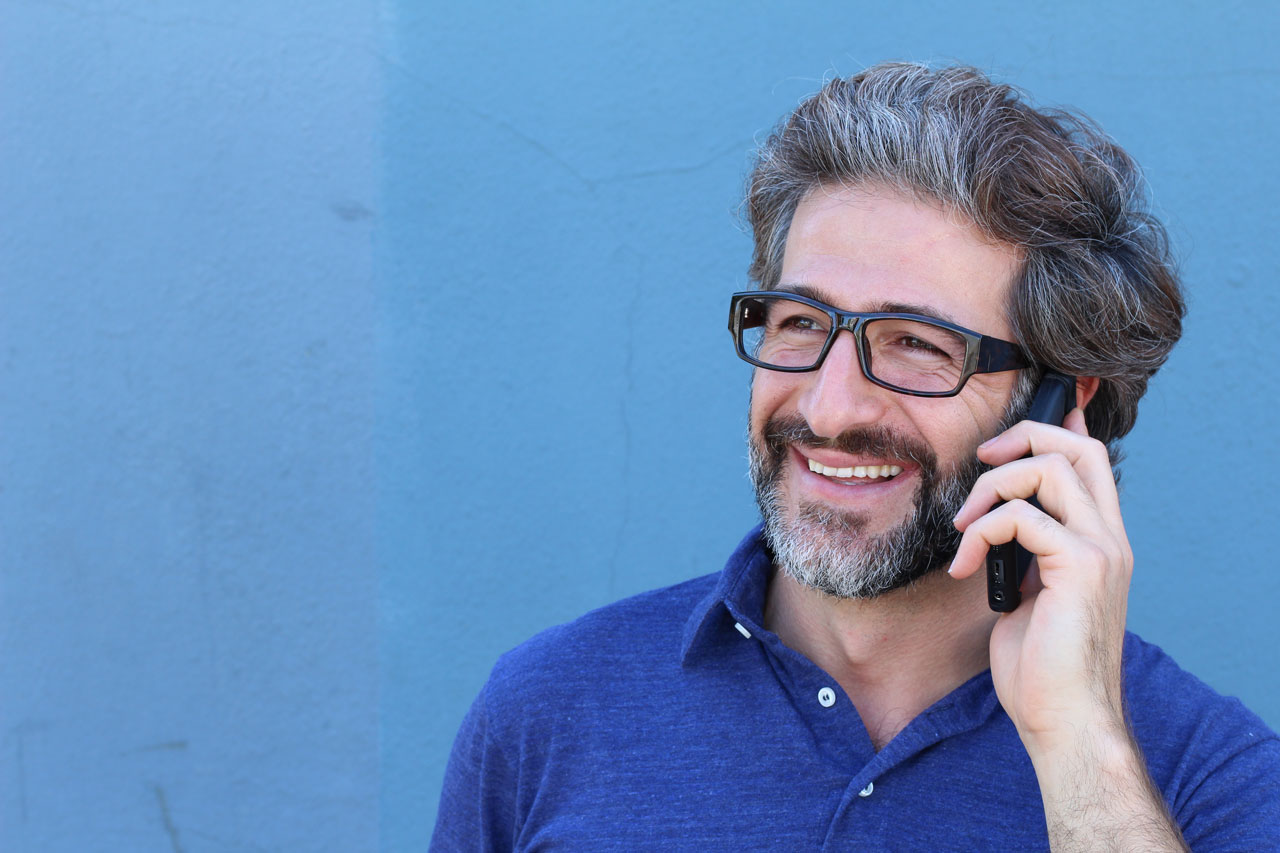Mężczyzna w okularach rozmawiający przez telefon komórkowy