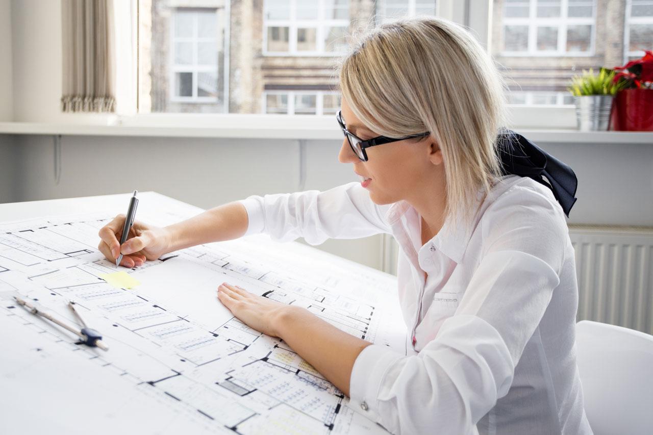Młoda architektka w okularach pracuje nad projektem