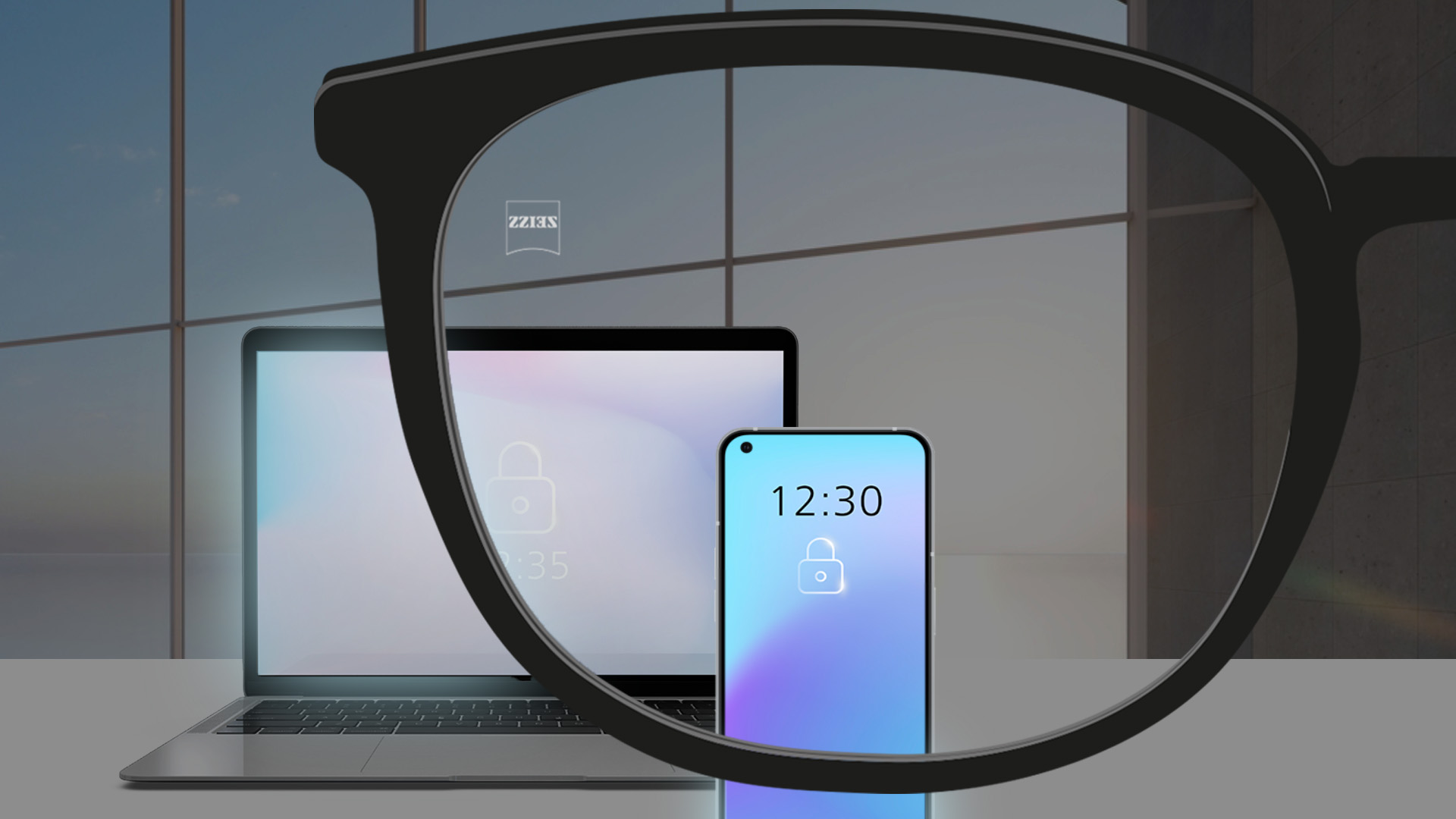 Zdjęcie przedstawiające laptopa i smartfon w przyciemnionym pomieszczeniu.