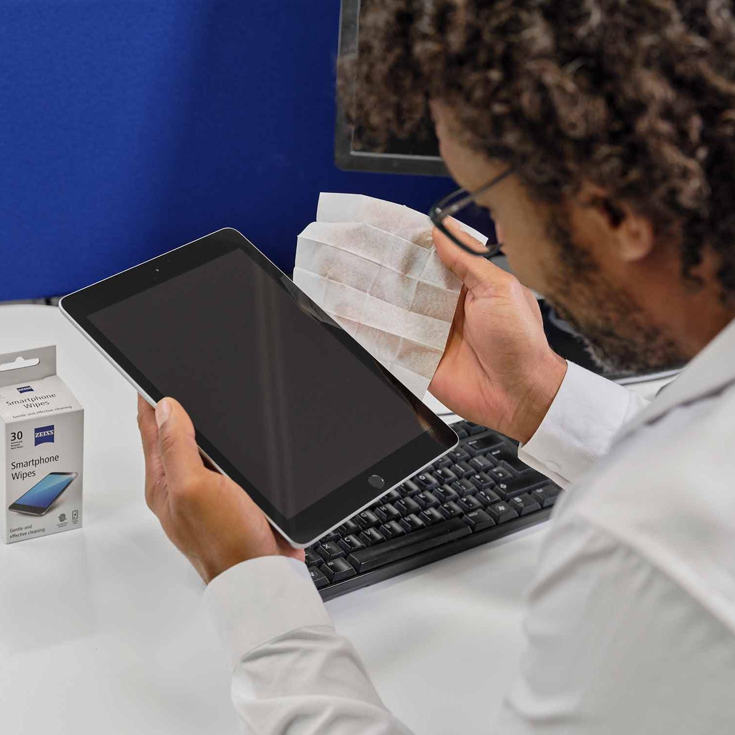 Mężczyzna czyszczący wyświetlacz tabletu za pomocą ściereczek do smartfona