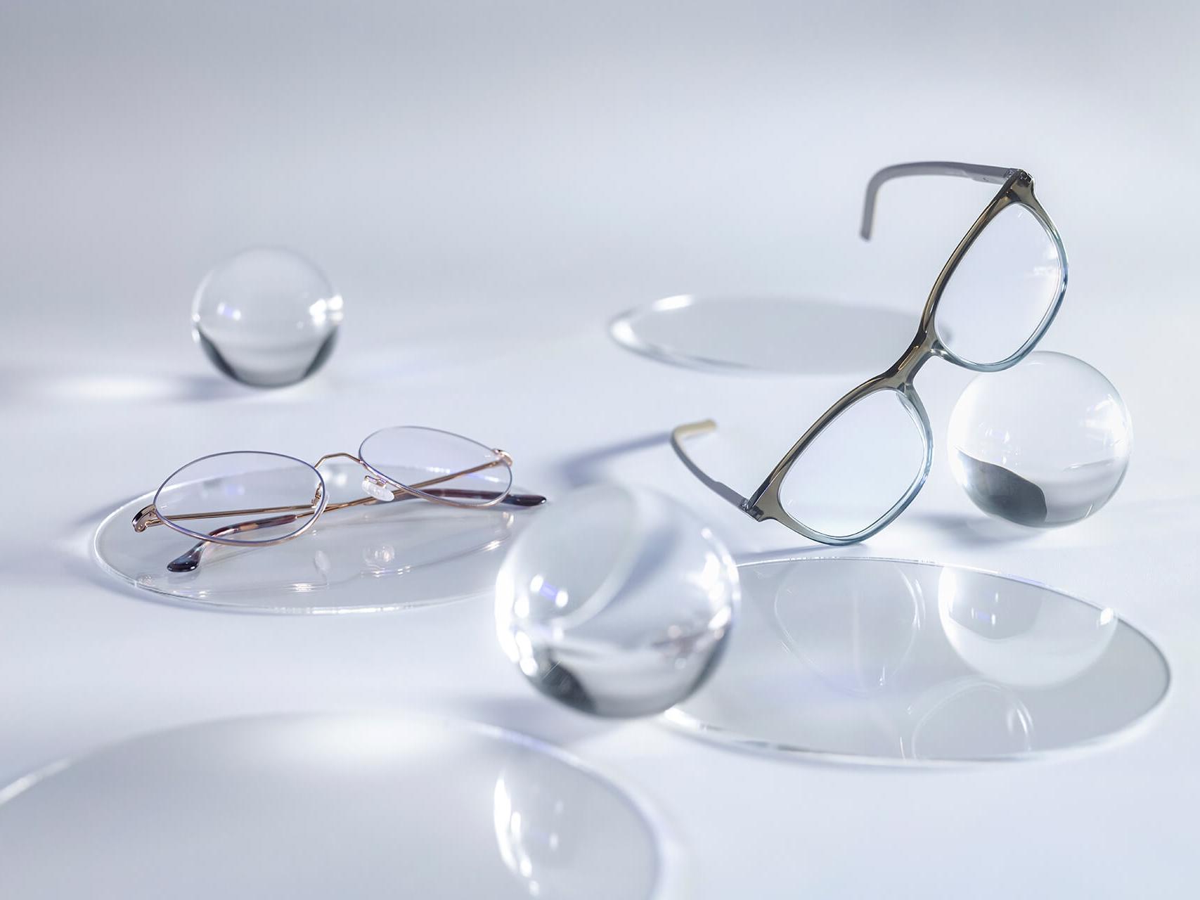 Okulary z soczewkami ZEISS, wyposażone w powłokę DuraVision® Silver nie odbijają światła w porównaniu do znajdujących się wokół szklanych kul.