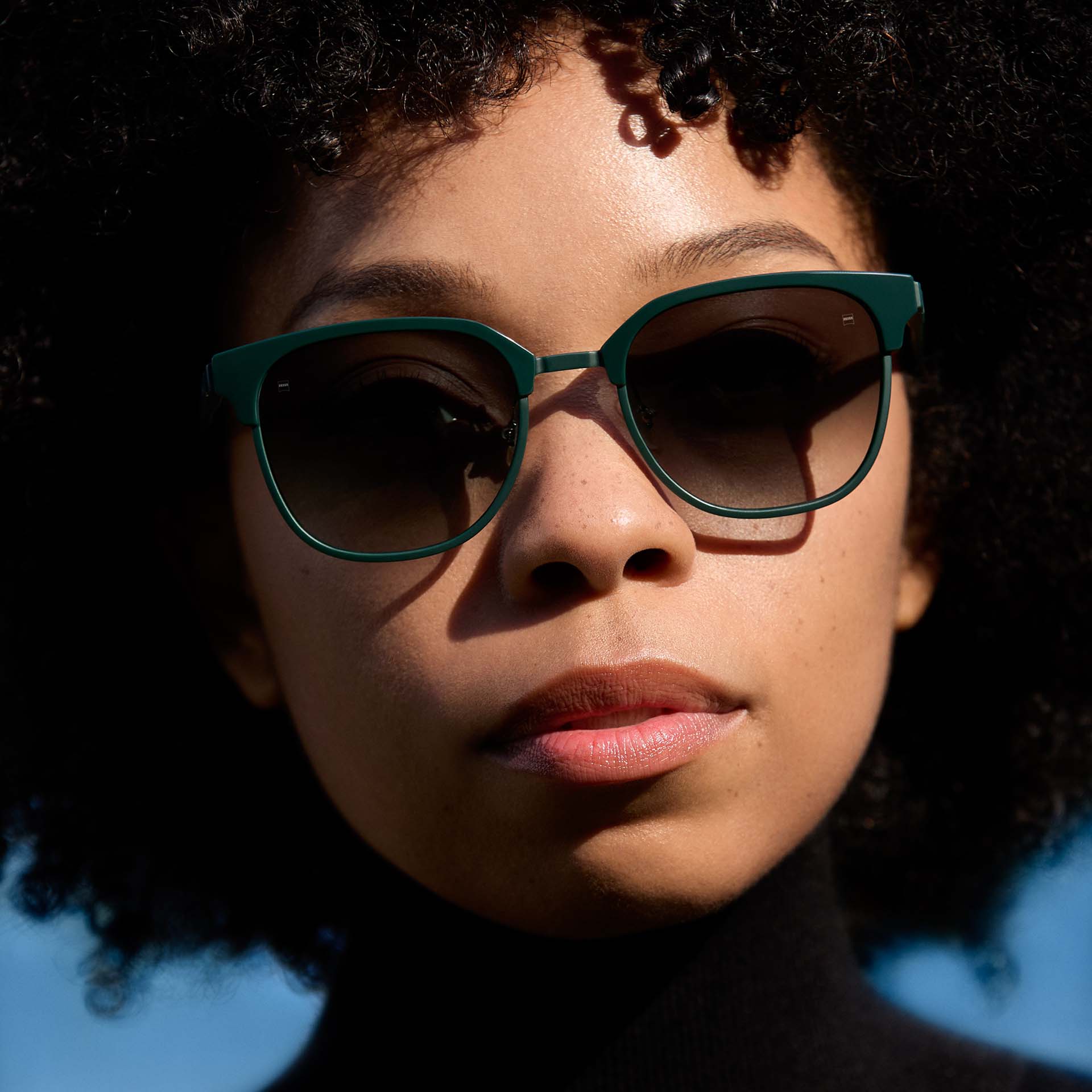 Kobieta nosząca zieloną oprawkę z soczewkami z gradientem. 