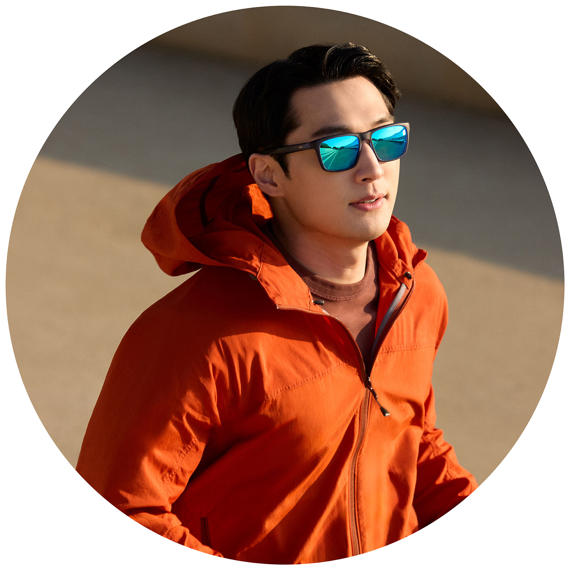 Biegacz w pomarańczowej kurtce w okularach przeciwsłonecznych ZEISS z mocą korekcyjną z niebieską powłoką lustrzaną.