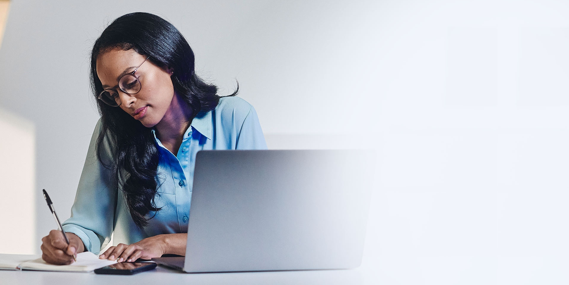 Kobieta nosząca okulary pracuje przy laptopie